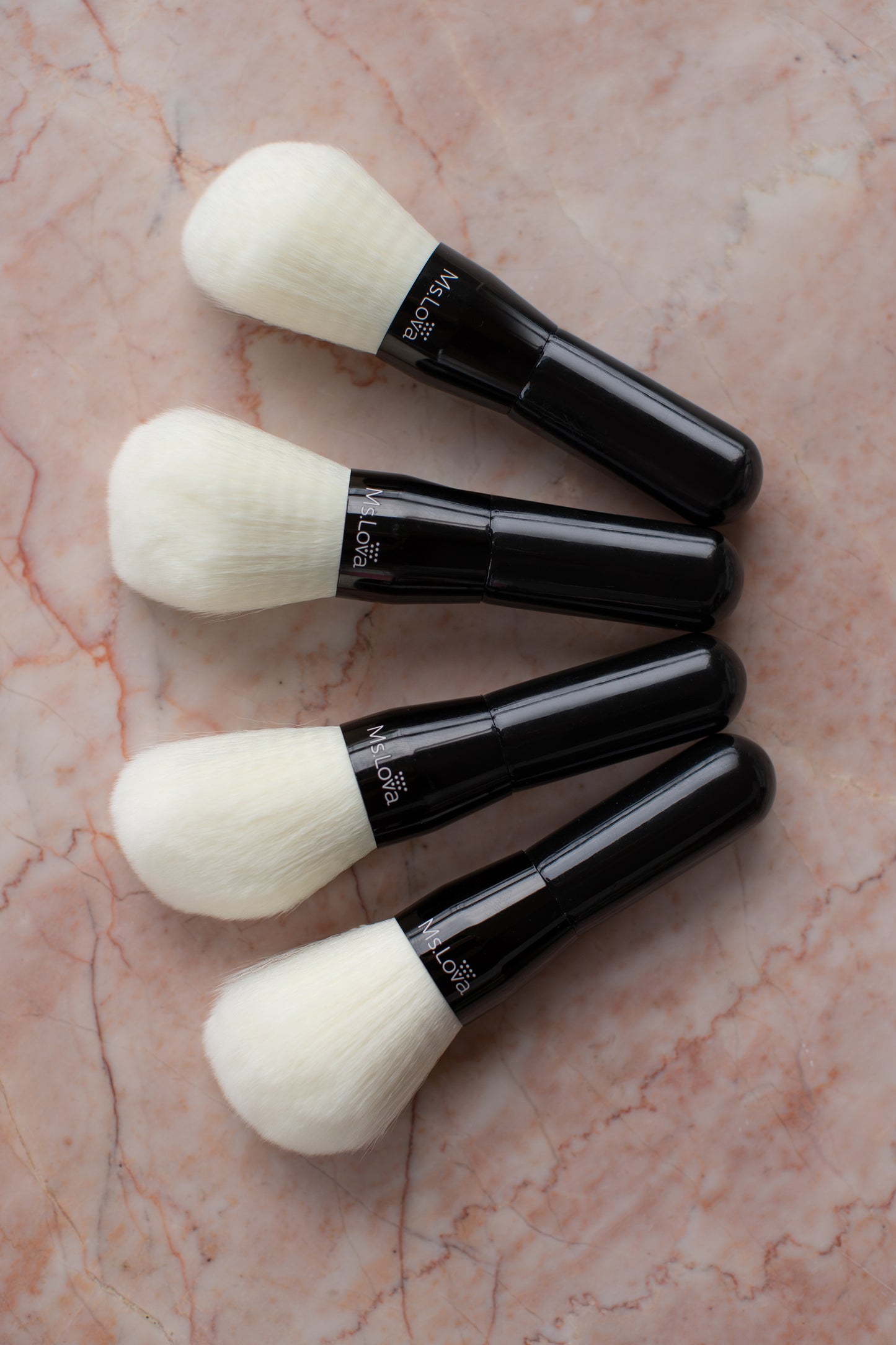 Collection of Ms.Lova self-tan blending brushes on pink marble background
