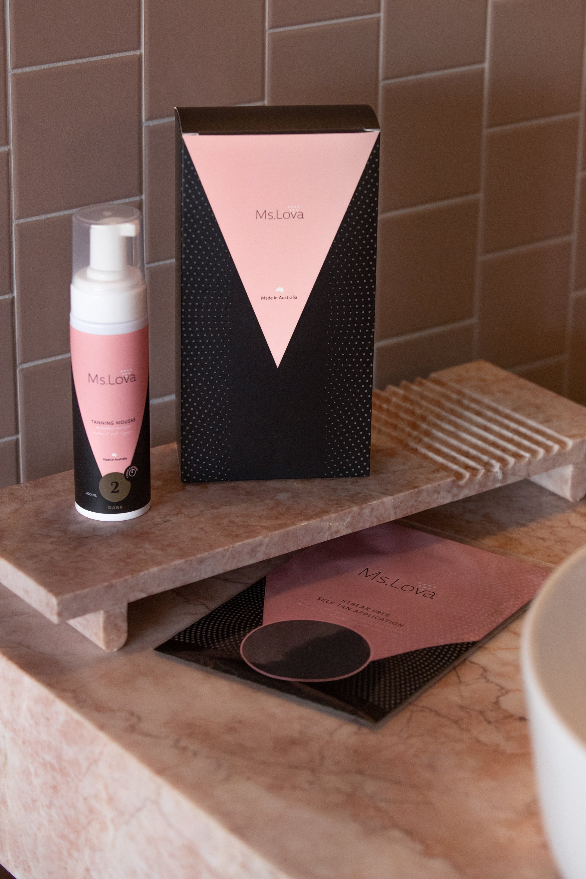 Ms. Lova Dark Express Tanning Mousse with packaging displayed on a bathroom counter